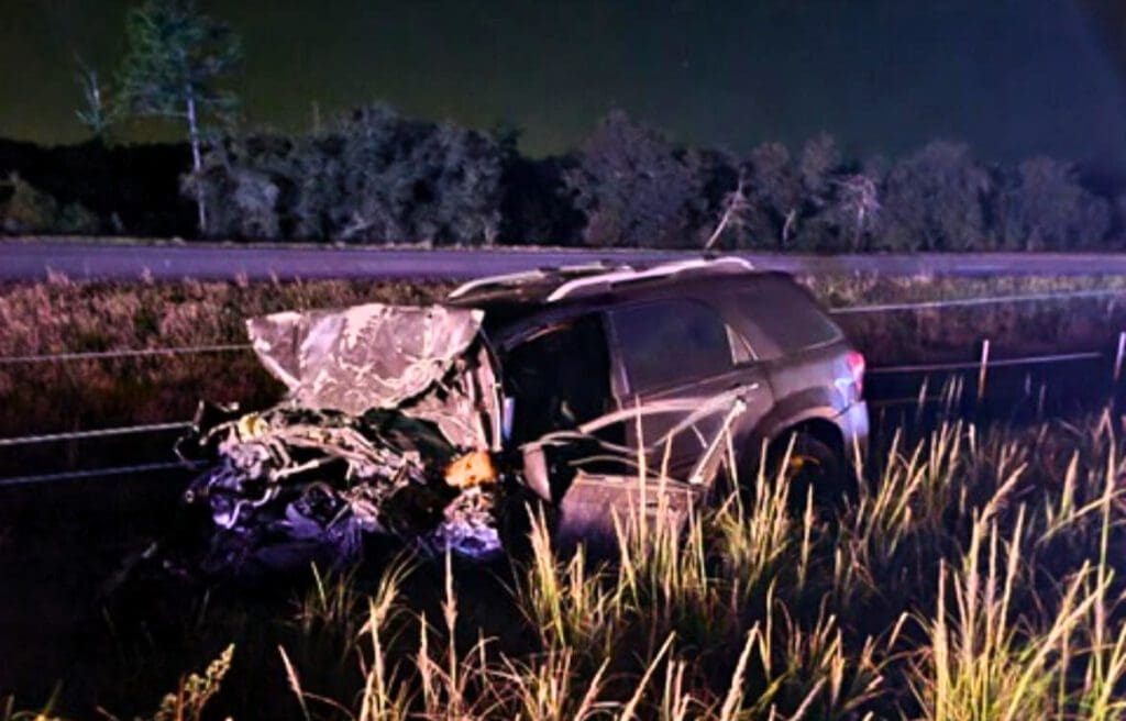 The author's wrecked car with the entire front end crumpled and the driver side door hanging off.