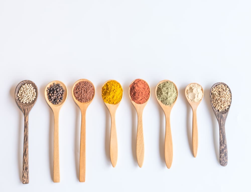 Wooden spoons full of colorful spices and seed depicting micronutriens for nutritional psychiatry