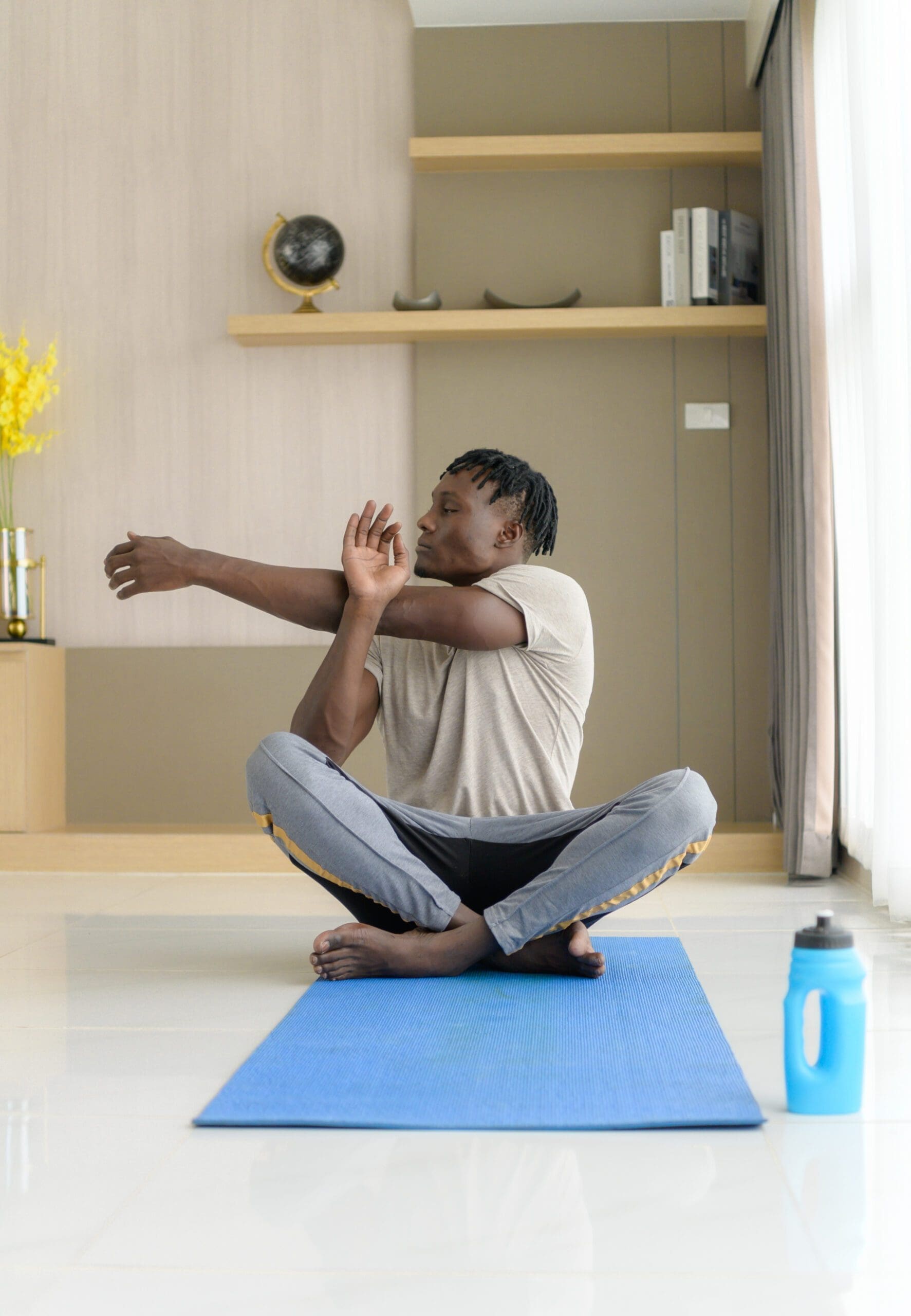 Young man of color doing yoga exercise in the living room of his homewith the pleasure of relaxing with light sports In the morning atmosphere of the day.