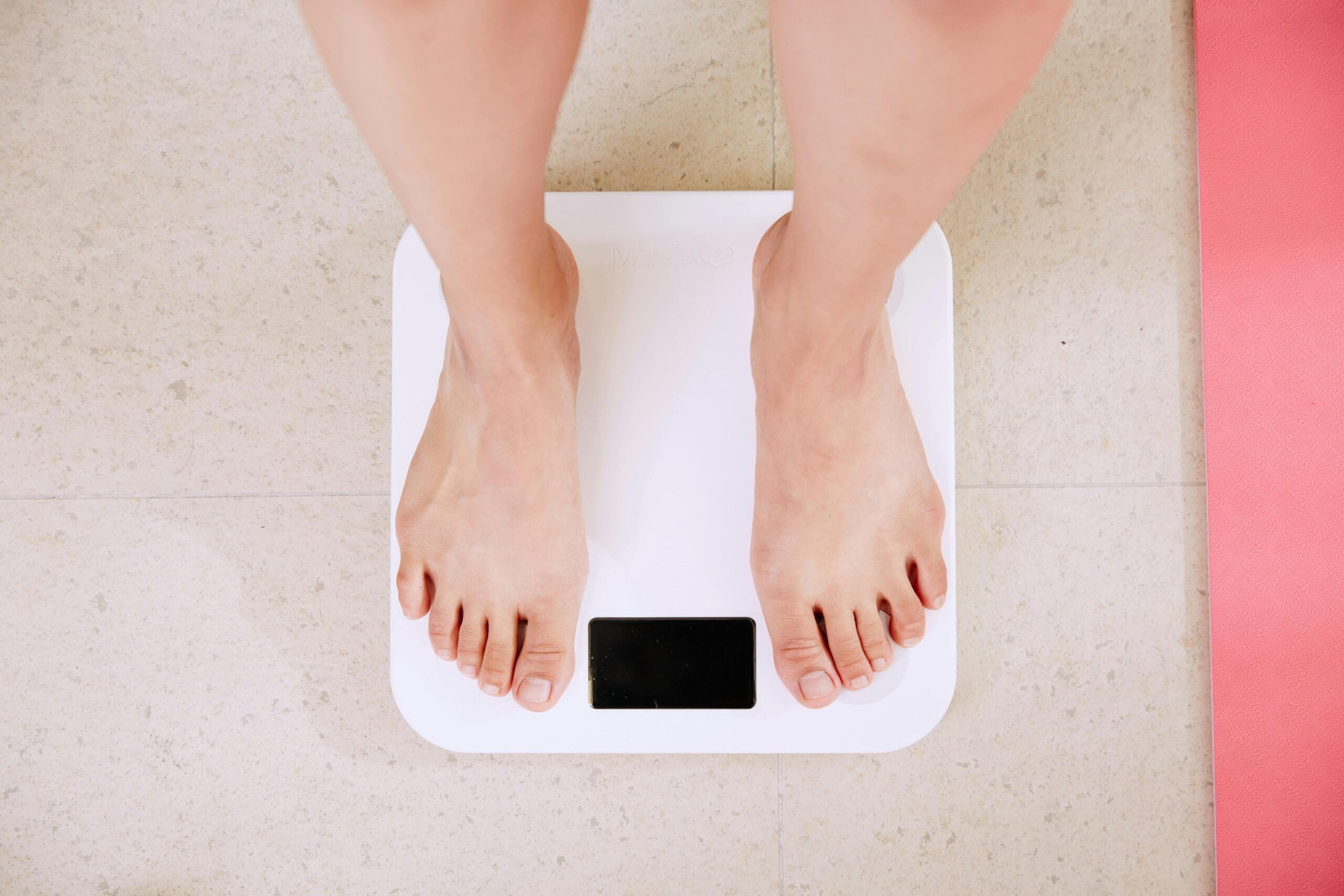 Feet standing on a scale representing having had weight loss surgery in Mexico.