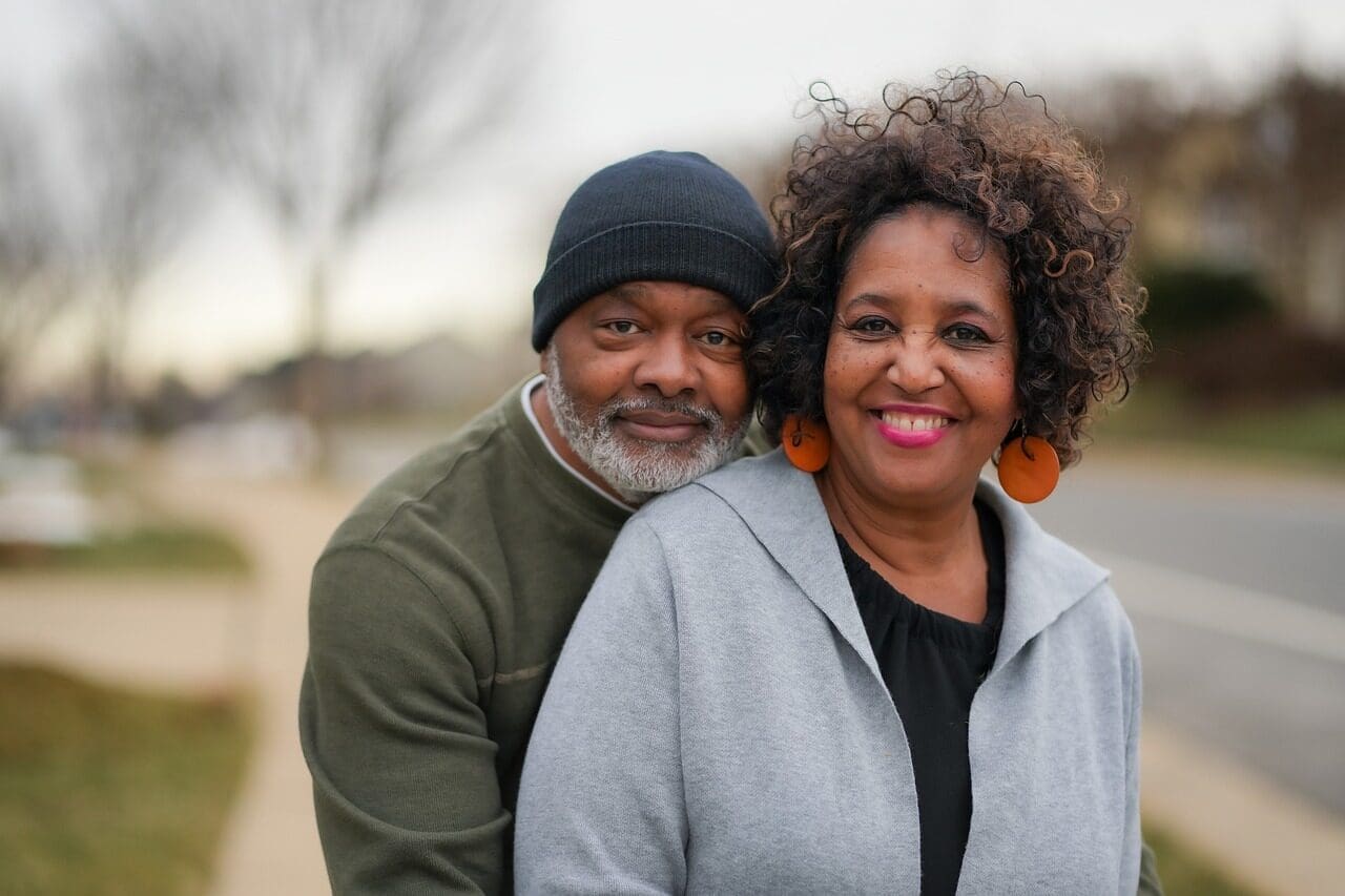 Older African-American couple embracing and looking happy. 