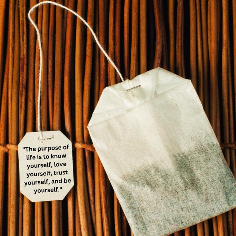 Dry herbal tea bag sitting on a bamboo mat, string and tag coming from the tea bag with a Yogi tea quote that reads "The purpose of life is to know yourself, love yourself, trust  yourself, and be yourself."