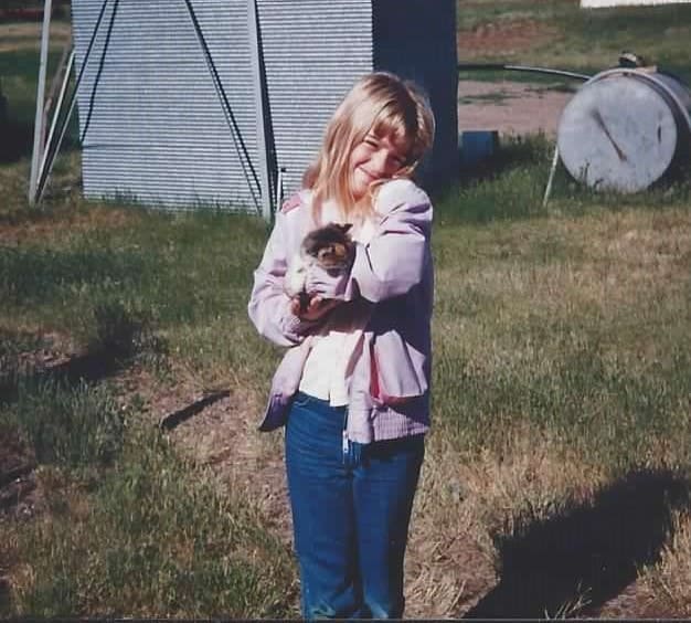 Young Donna holding a kitten at the farm belonging to her grandma and grandpa.