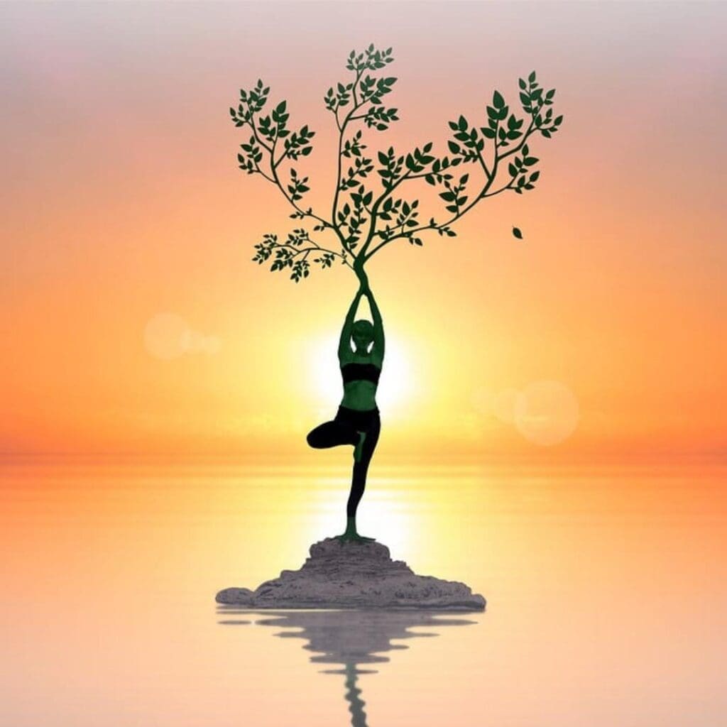 Woman standing on lone rock in the middle of the water with a glowing sunset behind her, she is standing in yoga 'tree pose' with tree growing from her hands.