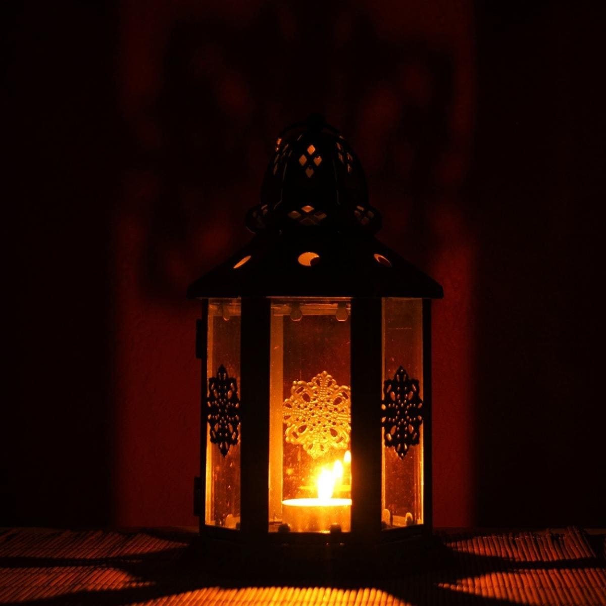 Photo of decorative lantern with candle burning inside. 